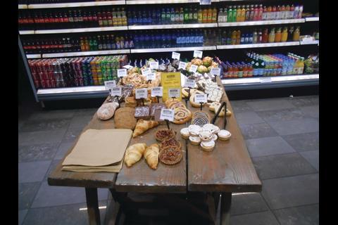 The store plays the artisan food game with wooden display tables and spotlights on the product instead of the shop as a whole.